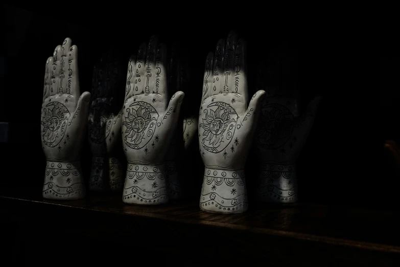 five white hands decorated with black and white designs