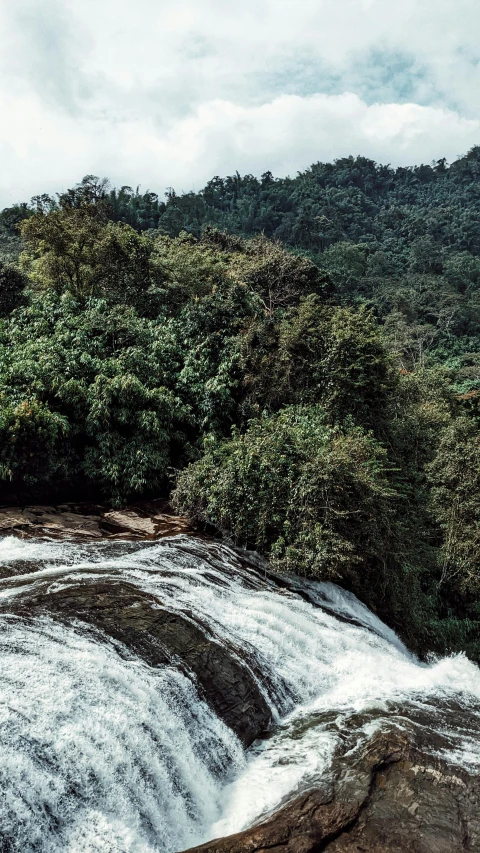 a very long waterfall in the middle of a forest