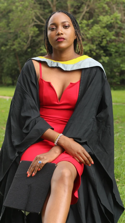 a woman sitting on a bench in her graduation gown