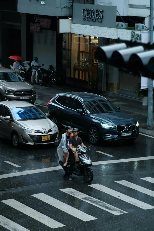 two men on a motorcycle riding down the street