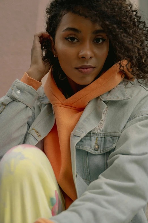 an african american female sits on a curb talking on a cell phone