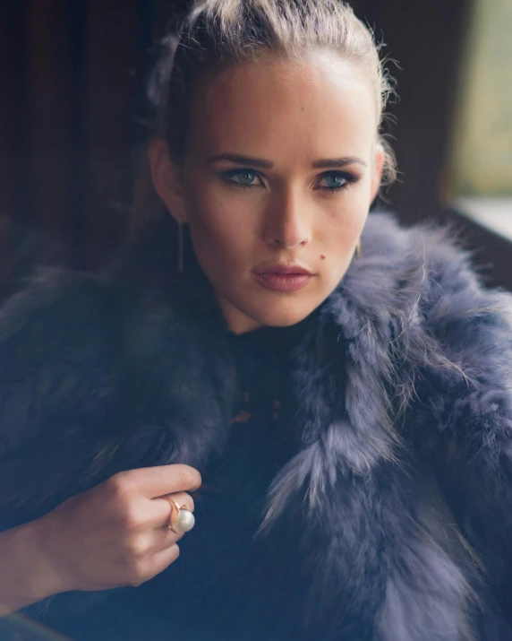 a woman with a feather coat stares into the distance