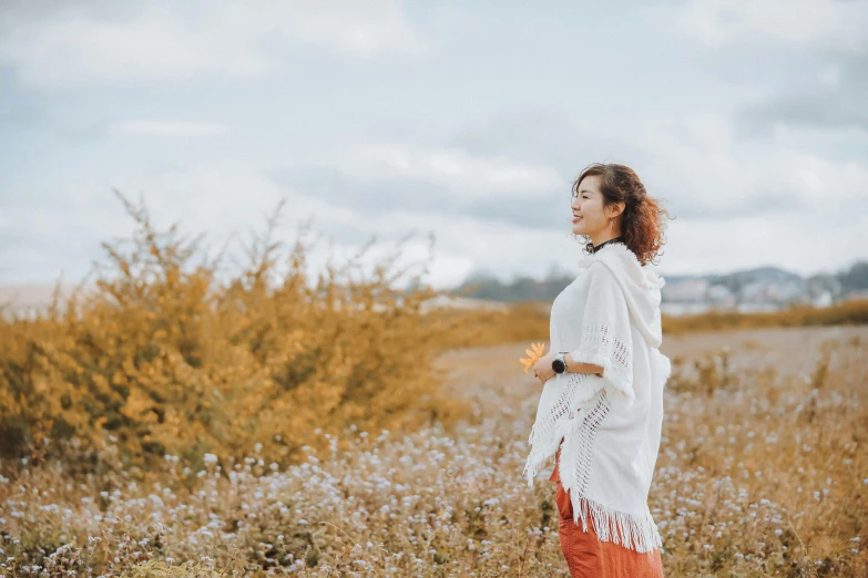 a woman standing in a field of tall grass