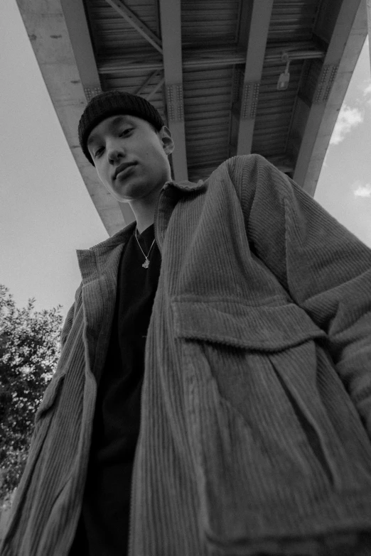 a man is dressed in all black while standing under a bridge