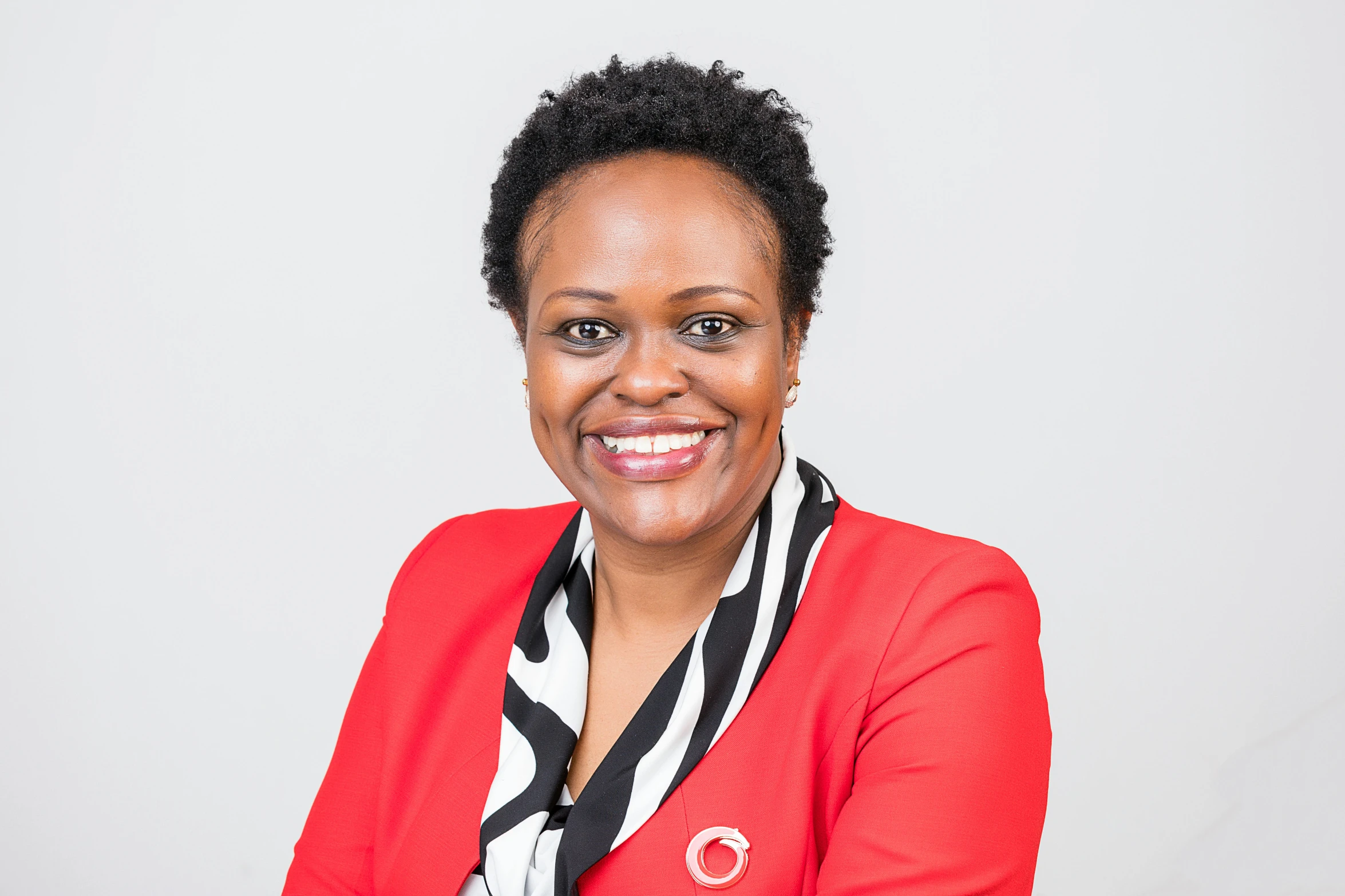 a woman with a red cardigan and white scarf smiling