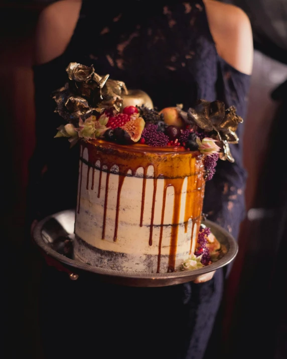 a beautiful white cake with berries and more with some brown glaze on it