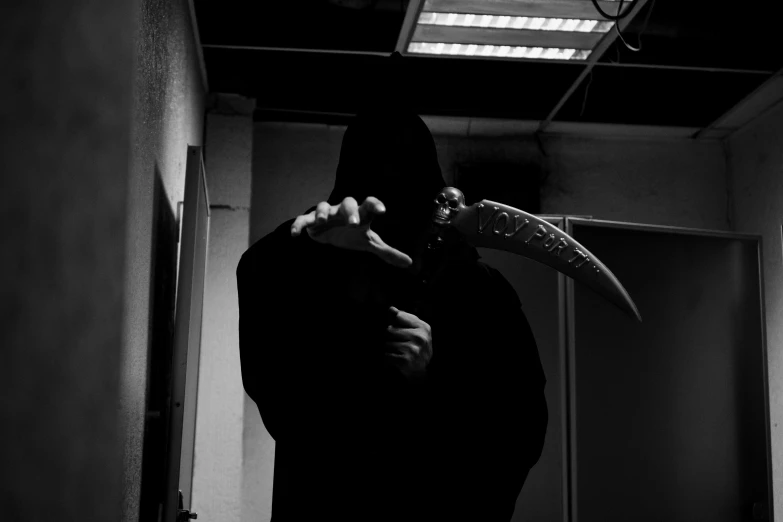 the man with a hooded face is holding a bird mask