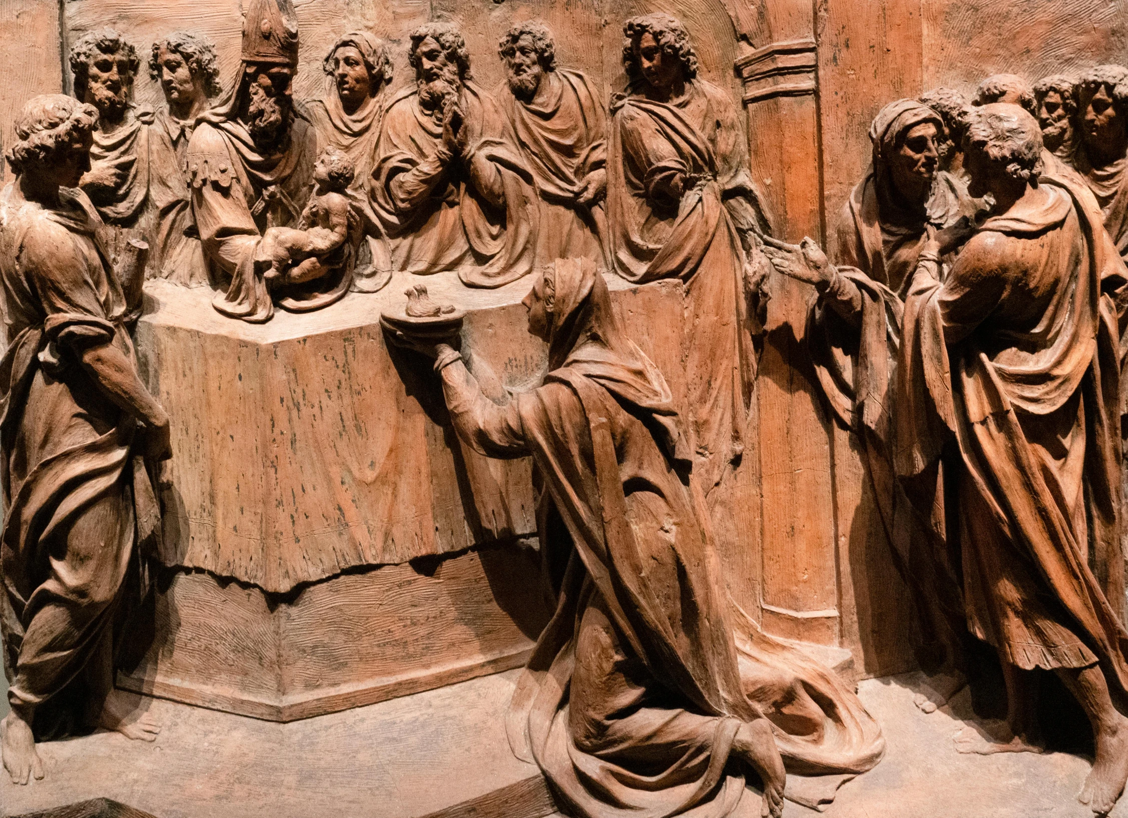 statues of women are lined up in front of a wall