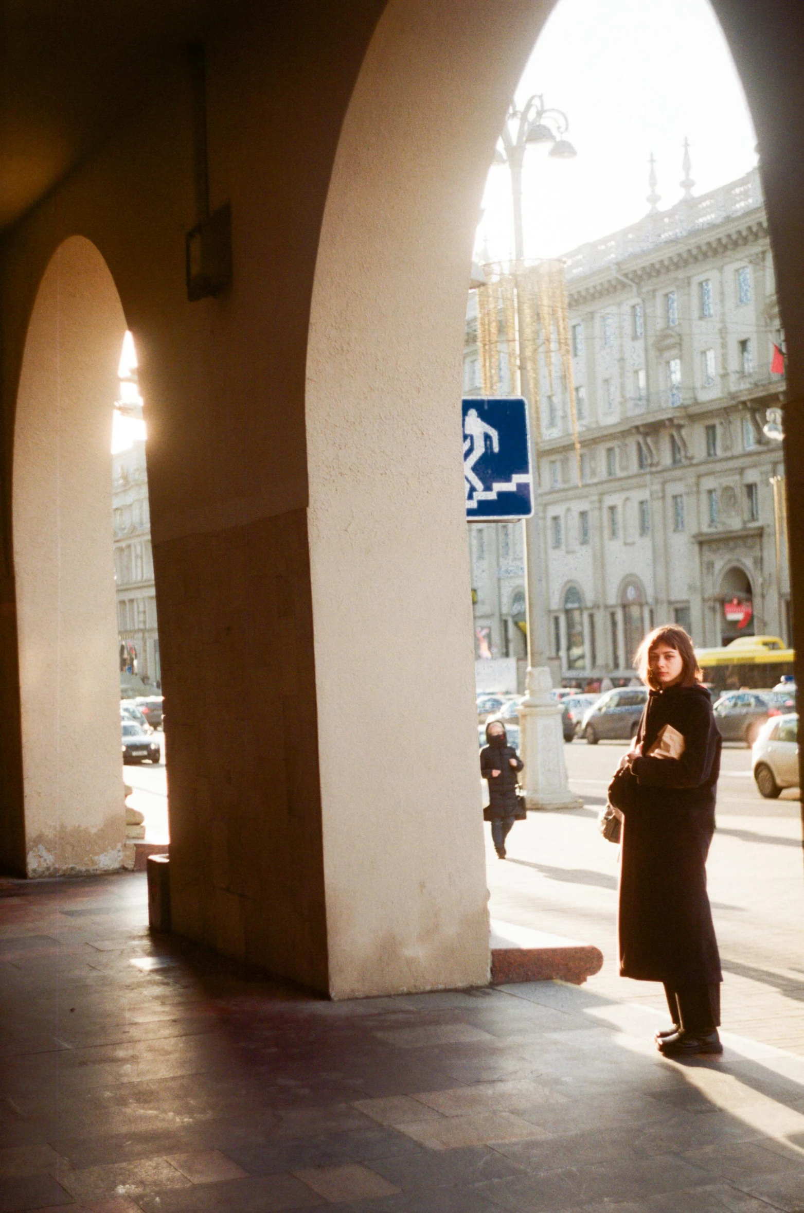 an archway leading to the right with the street sign and building in the background