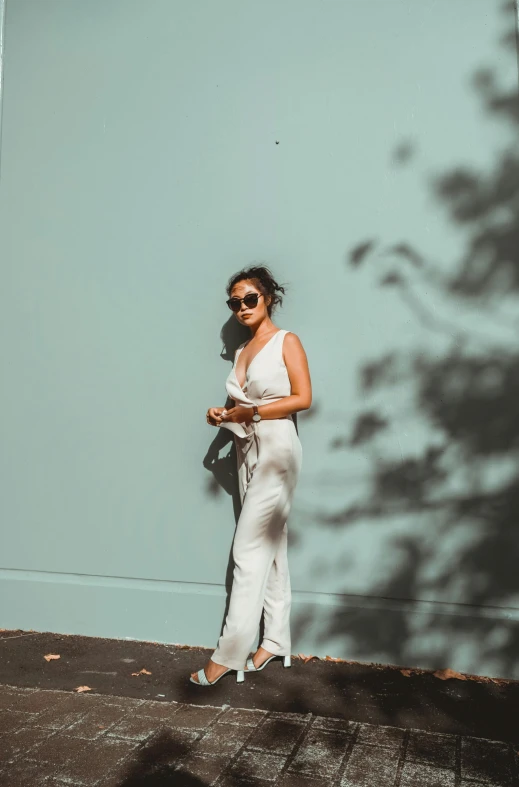 a woman is standing in front of a blue wall