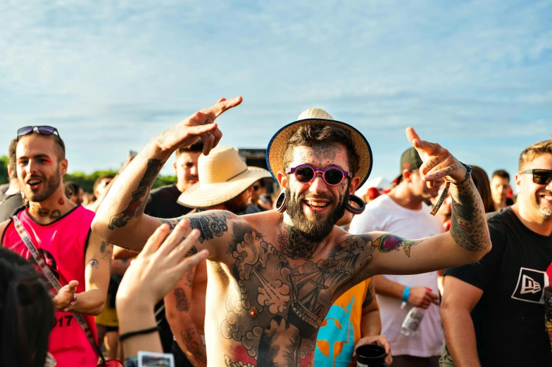 a person with all kinds of tattoos, some with arms, and his face painted