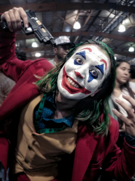 a person wearing clown makeup and holding a gun