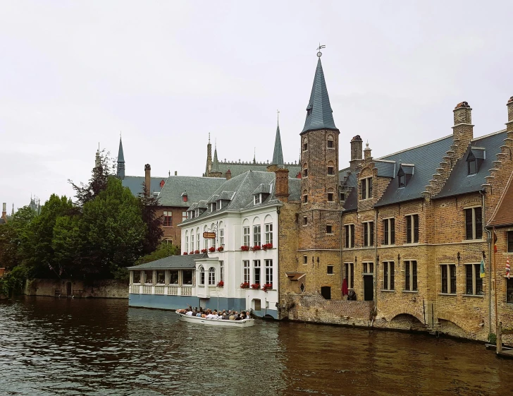 a building sits in front of a river and trees