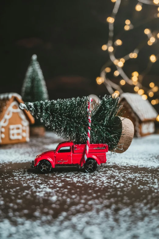 a truck carrying a christmas tree on a snow covered ground