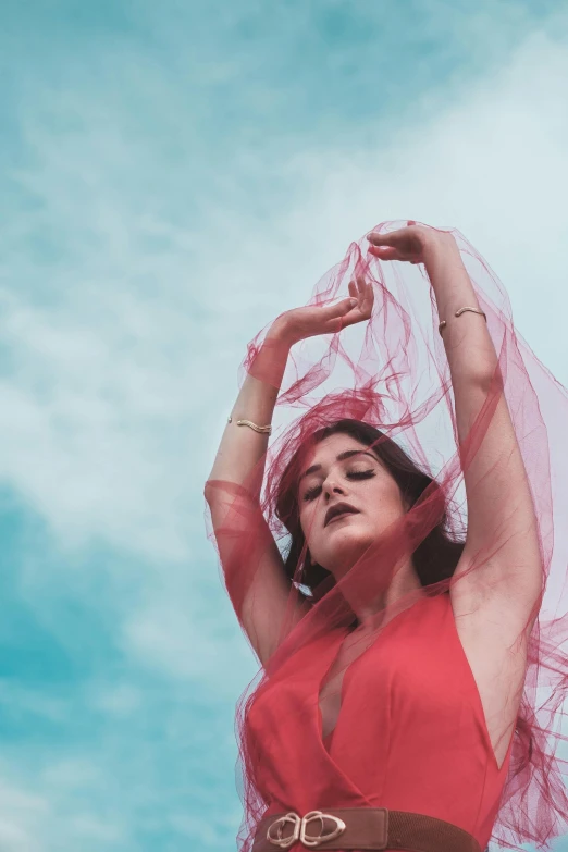 a woman in red is standing under a clear sky