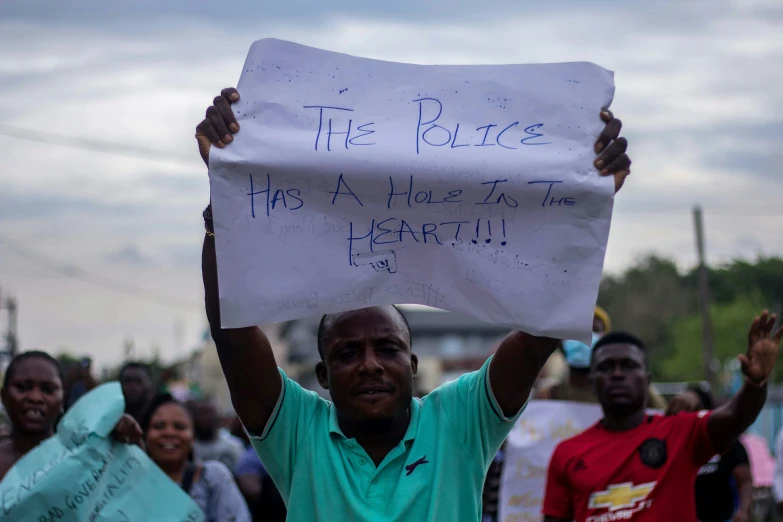 a man holding up a sign in front of other people