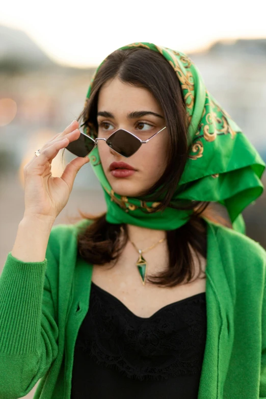 the woman in a green scarf is wearing a pair of glasses