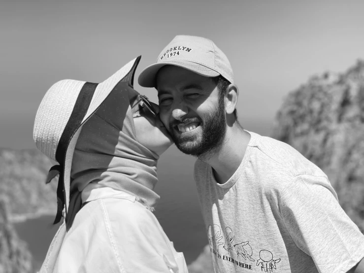 a black and white image of a guy and girl kissing