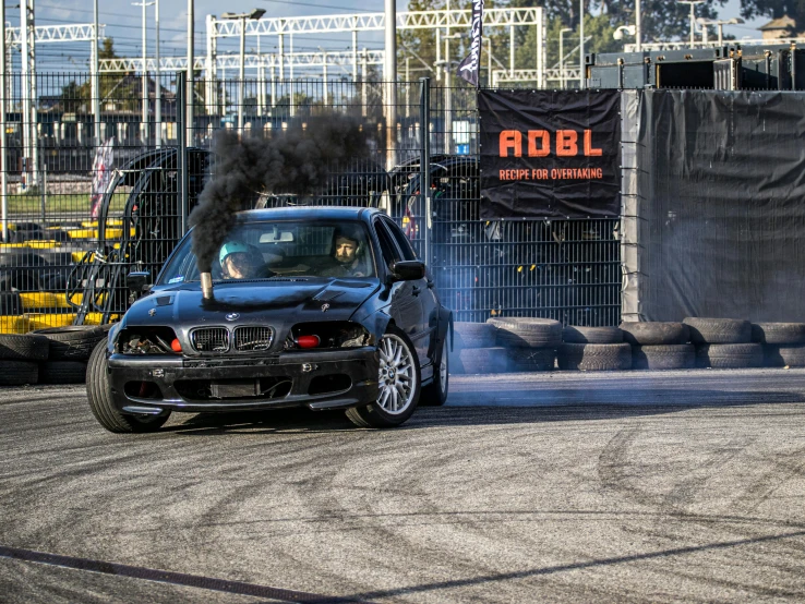 a black car with a lot of black smoke blowing out of its exhaust