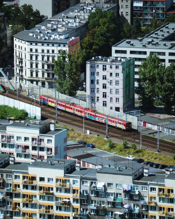 some buildings and a red train on its tracks