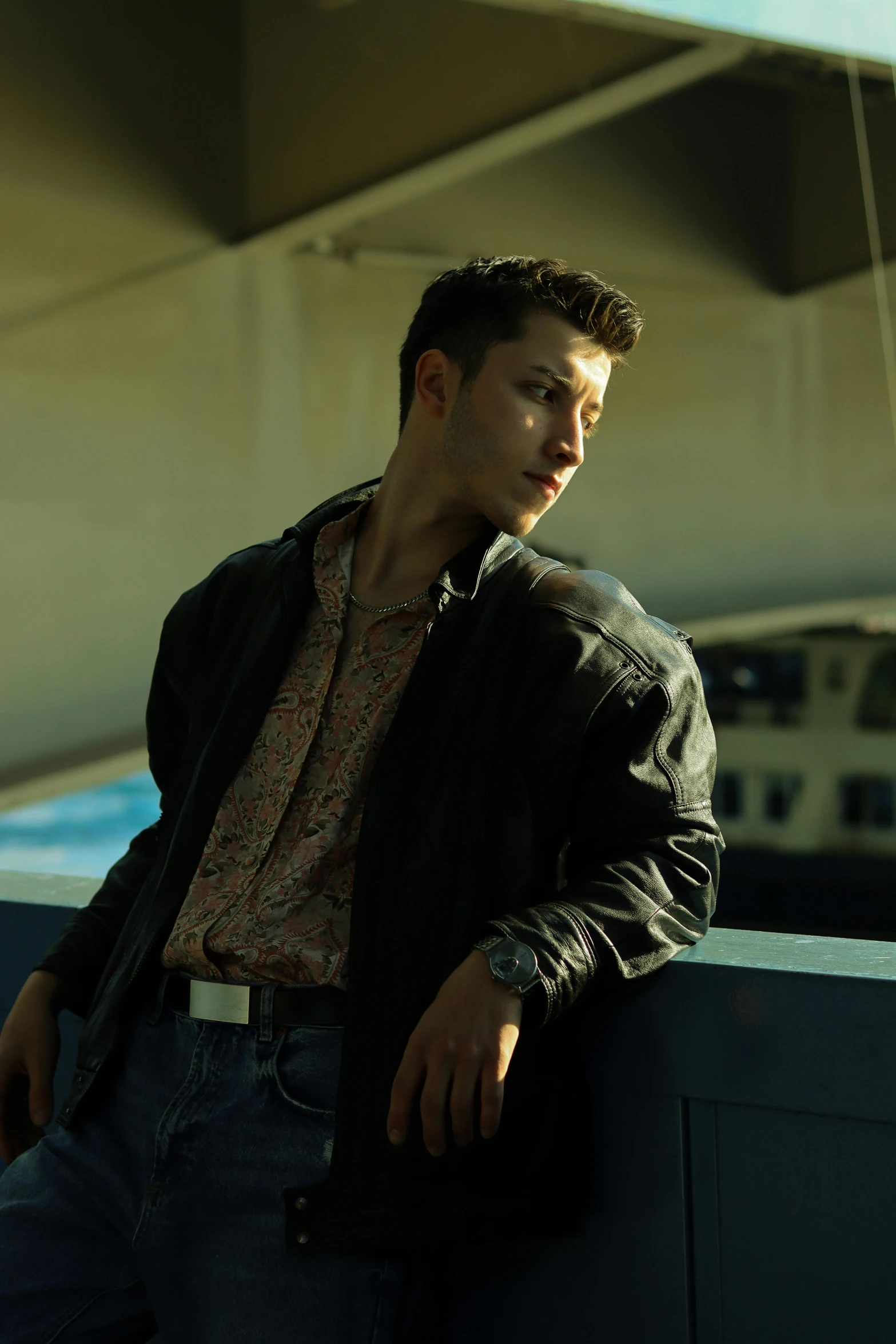 the man is posing for a po while leaning on the railing