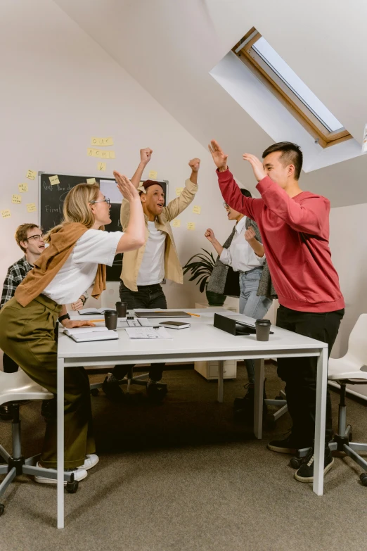 group of young adults raising hands on the roof of a room