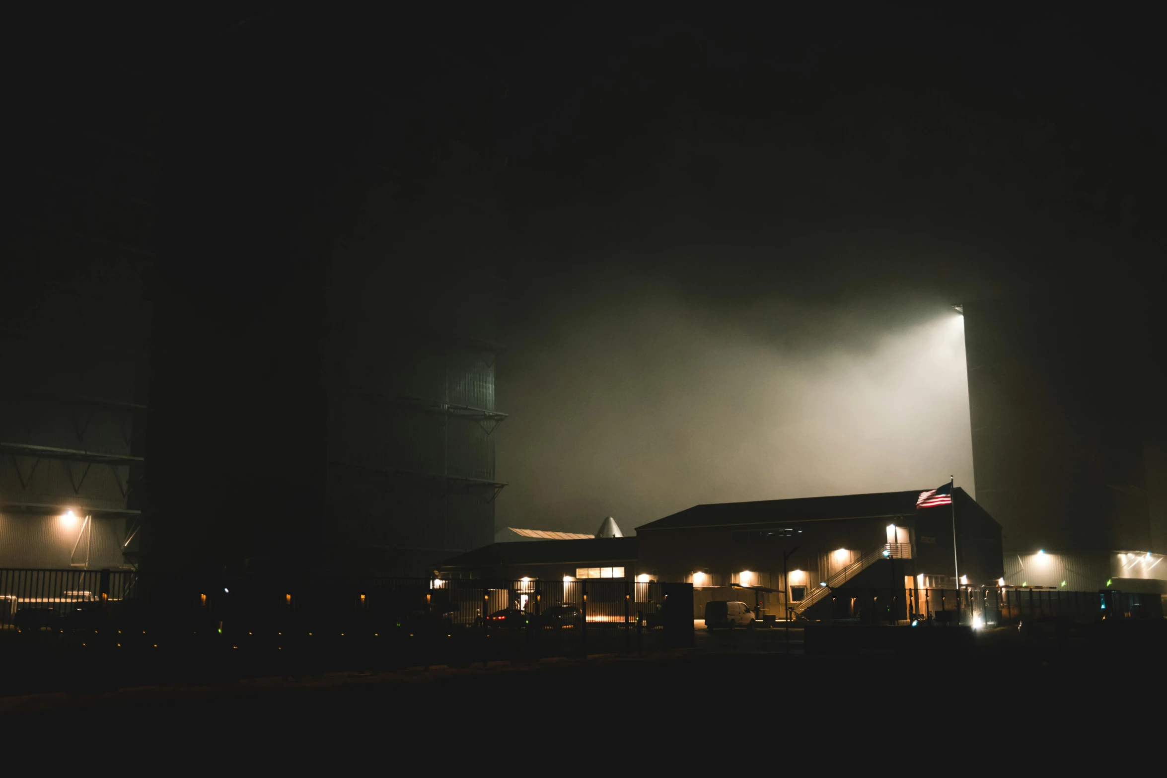 some buildings lights lights and fog in the night