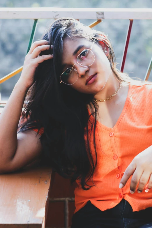 a girl sitting down on a bench holding her head in her hands