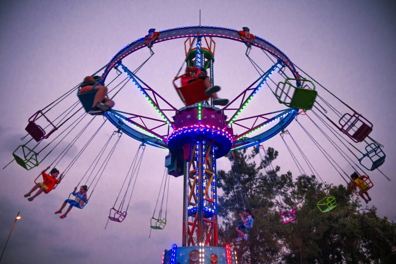 a carnival rides that has people flying around it