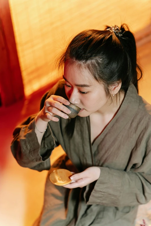 a young woman is taking a drink in front of her