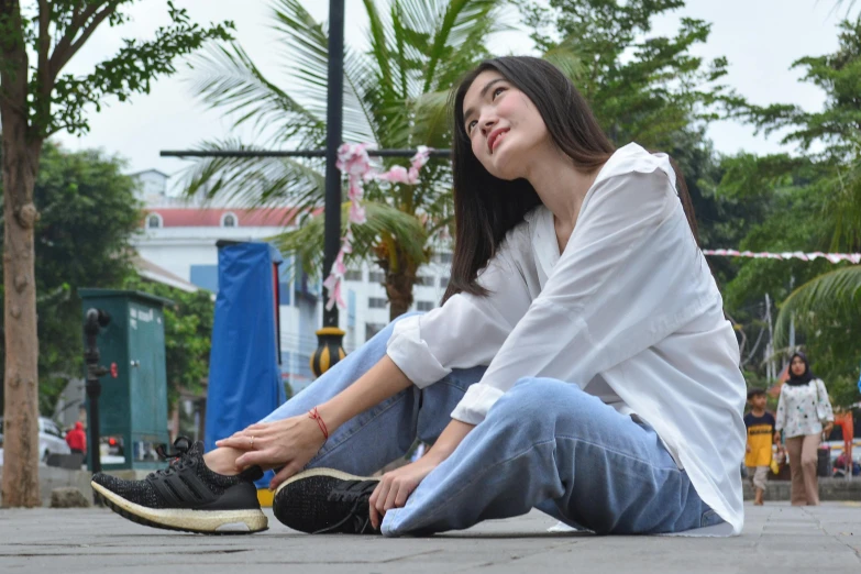 a woman sits on the ground and poses for a picture