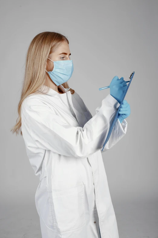 woman in a white lab coat and medical mask