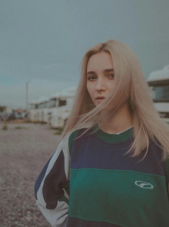 girl in green, blue and grey sweater standing on the street