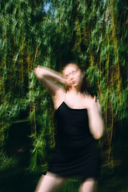 a woman is in the background of trees and plants