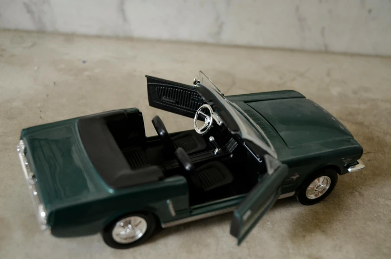 a small green toy car with an interior door open