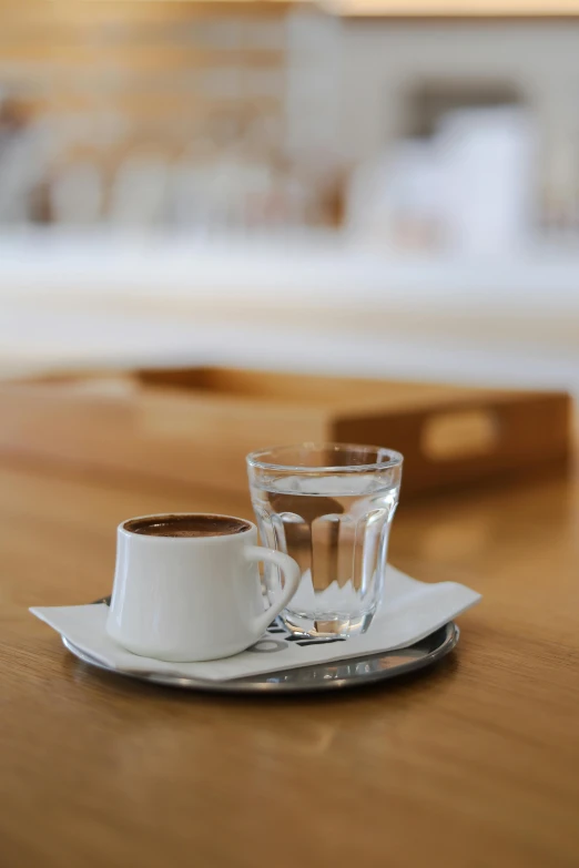 a close up of a cup on a plate with a drink in front of it