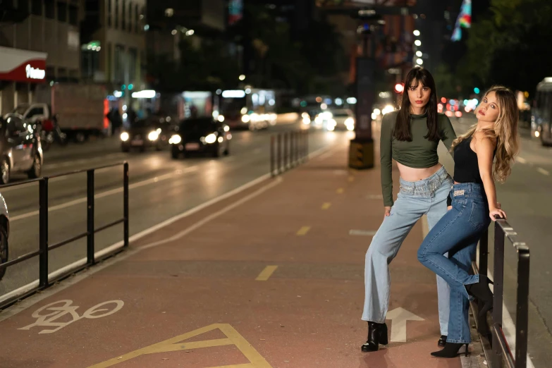 two woman standing on the street with a bicycle lane in the background