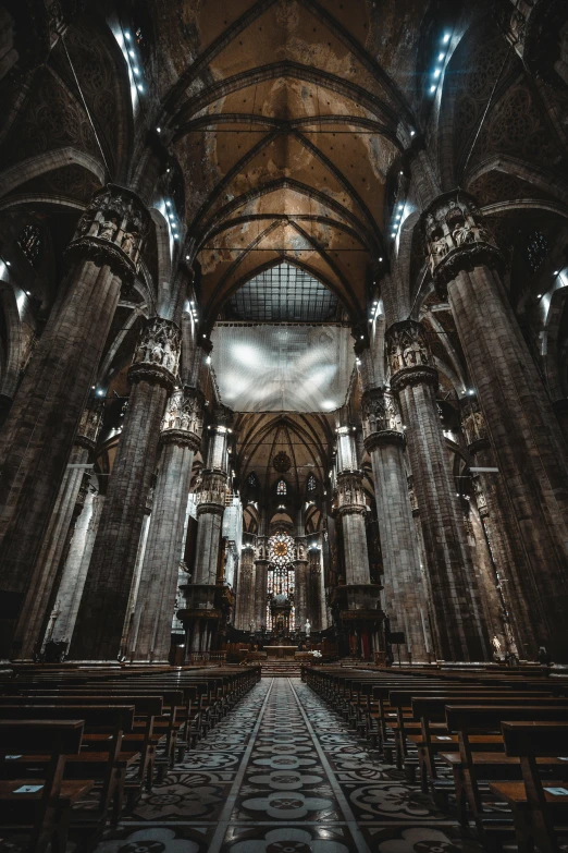 the interior of an ancient church with pews and lights