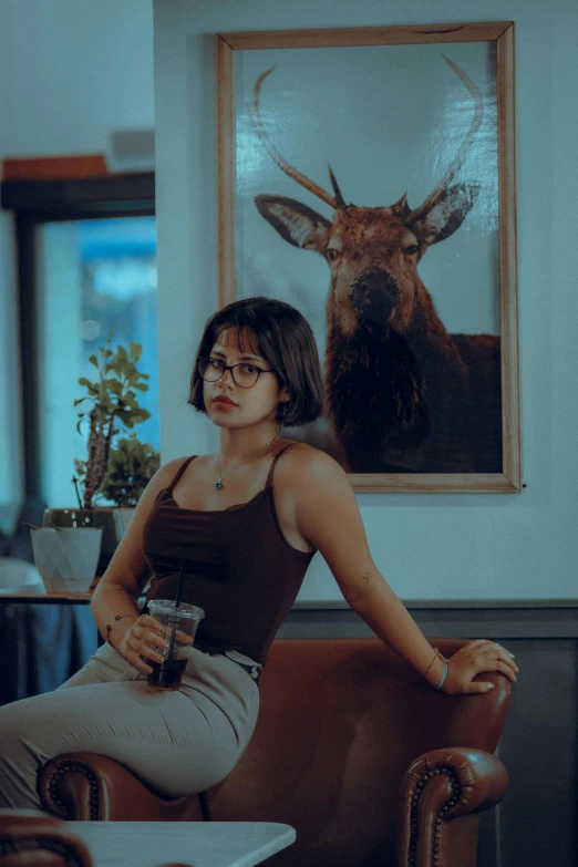 a woman in a chair is sitting next to a deer art