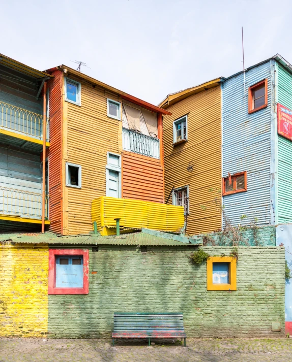 the city has multi - colored walls and a bench next to it