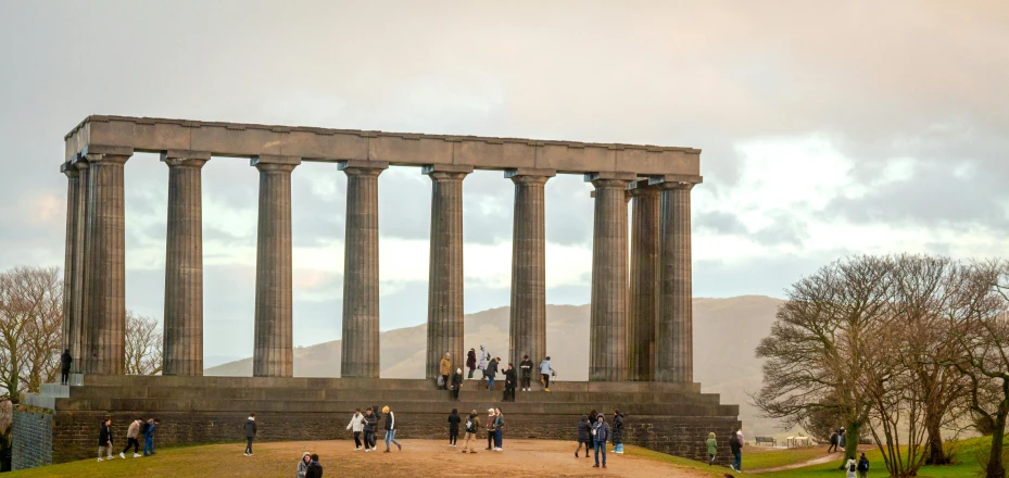 an old monument has two columns and people in it