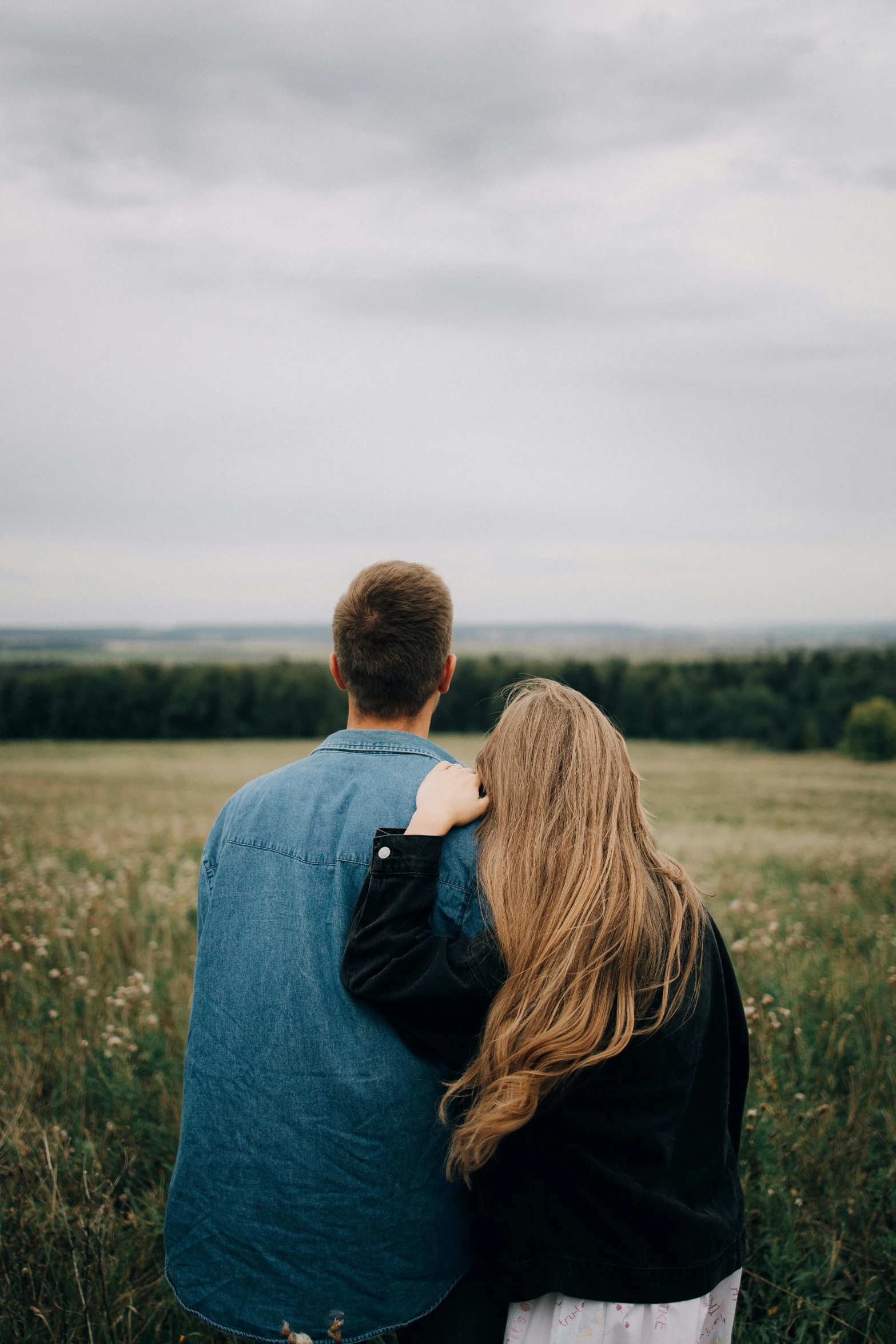 a couple looking at the vast expanse in an open field