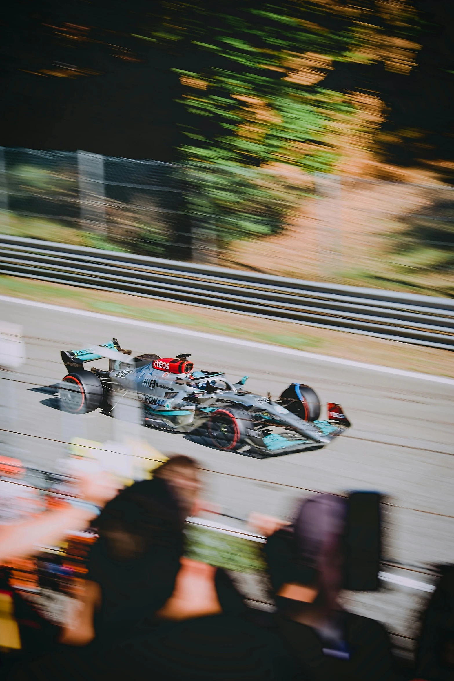 people standing around a race track watching race cars on the racetrack