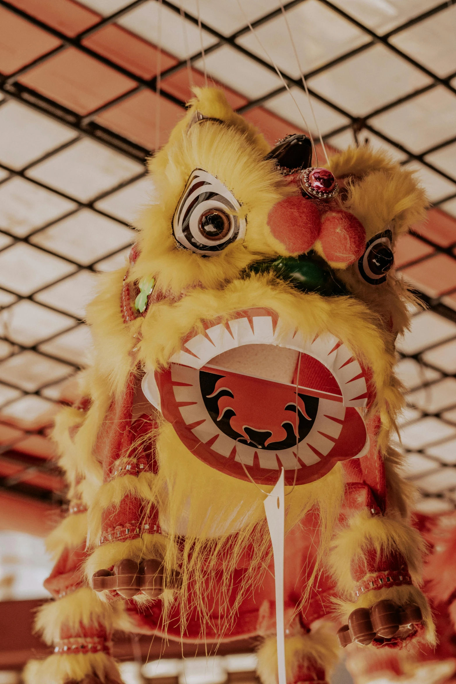 a close up of an oriental style lion mask on a stand