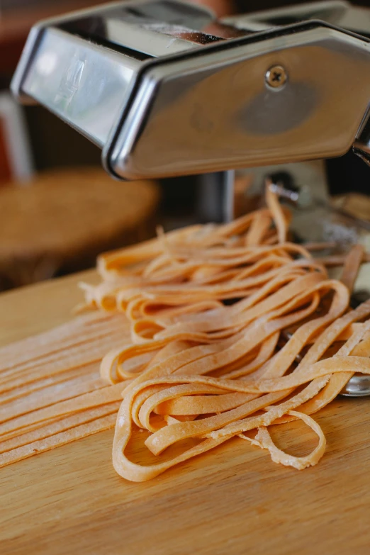 there is a pasta cutter next to some raw noodles