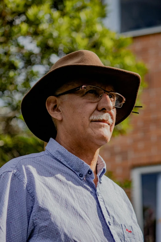 man wearing hat and glasses standing outside