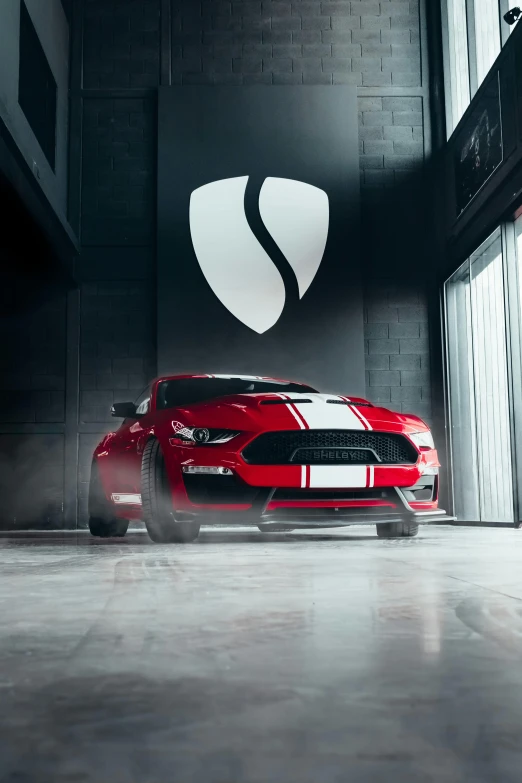 a red mustang car sits in a garage