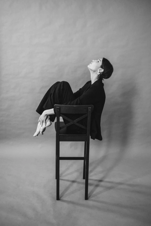 a black and white po of a person sitting on a chair