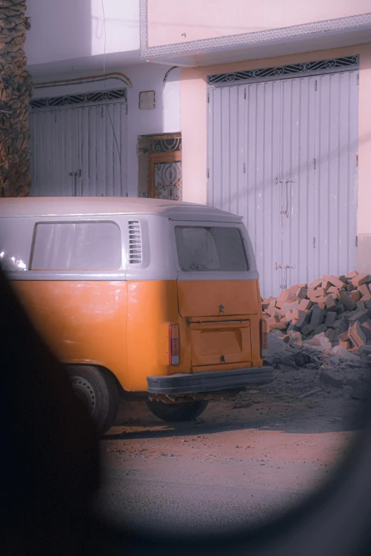 an orange and white van parked next to a building