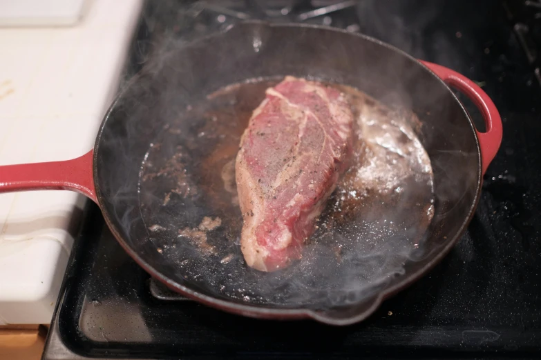 steak being fried in a pan on the stove